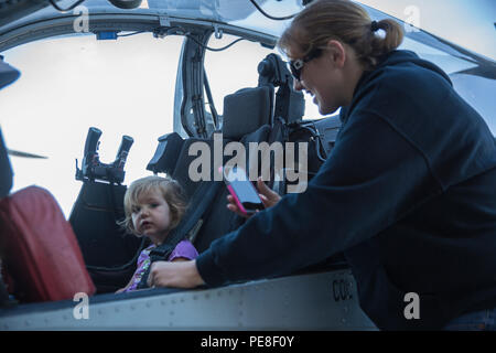 Michelle Patton, der Frau eines Marine mit Marine Leichter Hubschrauber Angriff Training Squadron (HMLAT) 303 und einem Nashville, Tenn., Eingeborener, nimmt Bilder ihrer Tochter Serenity während Sie sitzt im Cockpit eines AH-1W Super Cobra an Bord der Marine Corps Air Station Camp Pendleton, Calif., Okt. 24. Marines mit HMLAT-303 eingeladen, Angehörige und Gäste ihre geschwader zu Tour und Flugzeuge untersuchen. (U.S. Marine Corps Foto von Sgt. Lillian Stephens/Freigegeben) Stockfoto