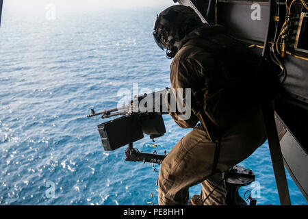 Golf von Oman (Okt. 2010) 29, 2015) US Marine Cpl. Mitchell Hintz Brände ein M240 medium Maschinengewehr aus einer MV-22 B Osprey. Hintz ist ein Crew Chief mit Marine Medium Tiltrotor Squadron 161 (verstärkt), 15 Marine Expeditionary Unit. Die Marines praktiziert Feuern auf Ziele im Wasser mit der Waffe vertraut zu bleiben und ihre Treffsicherheit verbessern. Die 15. MEU, auf den Schiffen der Essex Amphibious Ready Gruppe eingeleitet, wird die regionale Sicherheit in den USA 5 Flotte Bereich der Betrieb aufrecht zu erhalten. (U.S. Marine Corps Foto von Sgt. Anna Albrecht/Freigegeben) Stockfoto