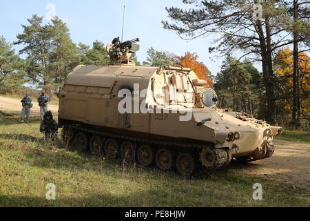 Us-Soldaten von Charlie Batterie, 1.Bataillon, 41 Field Artillery Regiment, 1st Armored Brigade, 3 Infanterie Division bieten Sicherheit nach Durchführung einer medizinischen Evakuierung während Beobachter Trainer Trainer, Links, des Joint Multinational Readiness Center (JMRC) während der Übung kombinierte Lösung V bei der US-Armee JMRC in Hohenfels, Deutschland, Okt. 26, 2015 beobachten. Übung kombinierte Lösung V wurde entwickelt, um der US-Armee regional zugeteilt, um die US-European Command Verantwortungsbereich mit multinationalen Ausbildung auf allen Ebenen zu trainieren. Etwa 4.600 Teilnehmer aus Stockfoto