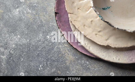 Vintage lackiert glasierte Teller, Schüsseln handgemachte auf grauem Beton Tabelle mit freier Speicherplatz ror Text. Stockfoto