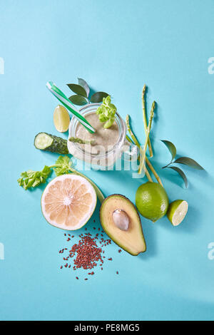 Grüne detox Smoothies aus Avocado, selery, Gurke mit Leinsamen in einem Glas auf einem blauen Hintergrund. Stockfoto