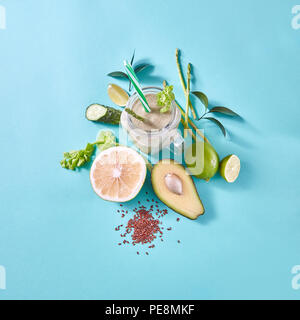 Gesundes Frühstück grüne Smoothies in ein Glas mit Avocado, selery, Gurke, Scheiben Zitrone mit Leinsamen in einem Glas auf einen blauen. Stockfoto