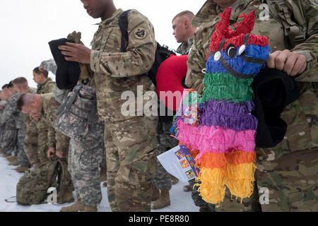 Ein Soldat der 98. Wartung Unternehmen zugewiesen, 17. Bekämpfung der Erhaltung Unterstützung Bataillon, U.S. Army Alaska, hält ein Geschenk für seine Familie vor einer Umschichtung Zeremonie Soldaten mit ihren Familien in den Buckner körperliche Fitness Center, Mittwoch, November 4, 2015, auf einer gemeinsamen Basis Elmendorf-Richardson, Alaska zu vereinen. Die "Wolverines" Südwesten Asien für neun Monate eingesetzt zur Unterstützung der Operation inhärenten lösen kann, und der Operation Enduring Freedom in Afghanistan. (U.S. Air Force Foto/Justin Connaher) Stockfoto