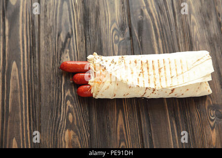 Hausgemachte Wurst in pita Brot auf hölzernen Hintergrund. Foto mit Stockfoto