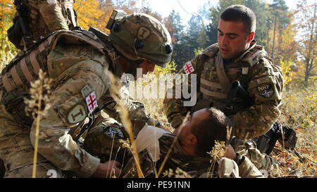 Georgische Soldaten von Charlie Company, 12 Leichte Infanterie Bataillon, 1 Infanterie Brigade, medizinische Hilfe bei einem simulierten Unfall während der Durchführung einer reagieren Szenario bei der US Army Joint Multinational Readiness Center in Hohenfels, Deutschland, Okt. 26, 2015 während der Übung kombinierte Lösung V zu kontaktieren. Übung kombinierte Lösung V wurde entwickelt, um der US-Armee regional zugeteilt, um die US-European Command Verantwortungsbereich mit multinationalen Ausbildung auf allen Ebenen zu trainieren. Rund 4.600 Teilnehmer aus 13 Nationen der NATO und der Europäischen Partner wird Teilnehmenden Stockfoto