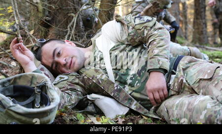 Ein fiktiv verletzt georgischen Soldaten von Charlie Company, 12 Leichte Infanterie Bataillon, 1 Infanterie Brigade, ruht in einem simulierten Unfall Sammelstelle vor der Extraktion durch medizinische Evakuierung Personal während der Durchführung einer reagieren Szenario bei der US Army Joint Multinational Readiness Center in Hohenfels, Deutschland, Okt. 26, 2015 während der Übung kombinierte Lösung V zu kontaktieren. Übung kombinierte Lösung V wurde entwickelt, um der US-Armee regional zugeteilt, um die US-European Command Verantwortungsbereich mit multinationalen Ausbildung auf allen Ebenen zu trainieren. Etwa 4 Stockfoto