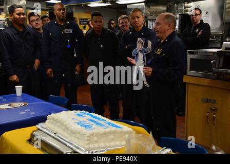 151112-N-ZZ 999-001 ATLANTIK (Nov. 12, 2015) USS Carney (DDG64) kommandierenden Offizier, Cmdr. Ken Pickard in Pensacola, Fla., bereitet eine Veterans Day Feier Kuchen für die Crew zu schneiden, während "David", ein Papier geschnitten aus jungen David Farragut angesichts der Besatzung als Partner in der Bildung mit David Farragut an der Volksschule, an Bord der USS Carney (DDG64) Nov. 12, 2015. Carney, einem der Arleigh-Burke-Klasse geführte-missile Destroyer, vorwärts zu Rota, Spanien ist die Durchführung einer Routinepatrouille in den USA 6 Flotte Bereich der Maßnahmen zur Unterstützung der US-amerikanischen nationalen Sicherheitsinteressen in Europ Stockfoto