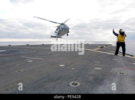 151112-N-VY489-011-Mittelmeer (12. November 2015) als Zivildienst Seemann leitet einen MH-60 Seahawk Hubschrauber, zugeordnet zu den Ghost Fahrer der Hubschrauber Meer bekämpfen Squadron (HSC) 28, vor allem beim Start aus den USA 6. Flottenkommando und Kontrolle Schiff USS Mount Whitney (LCC-20) 12. November 2015. Mount Whitney, nach vorn eingesetzt nach Gaeta, Italien, arbeitet mit einer kombinierten Mannschaft von Matrosen und Military Sealift Command Staatsdienst Seeleute. (Foto: U.S. Navy Mass Communication Specialist 1. Klasse Mike Wright / veröffentlicht) Stockfoto