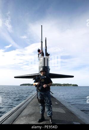 151104-N-ZZ 999-470 SUBIC BAY, Philippinen (Nov. 4, 2015) ein Seemann steht eine bewaffnete Sicherheit zusehen, wie die Los Angeles-Klasse schnell-Angriffs-U-Boot USS Key West (SSN722) Transite Subic Bay. Key West besucht die Philippinen als Teil seiner Indo-Asia-Pazifik-Bereitstellung. (U.S. Marine Foto von kulinarischen Specialist 1. Klasse Christopher Rose/Freigegeben) Stockfoto