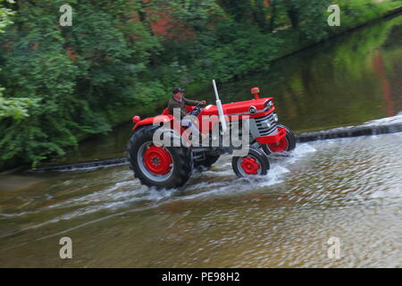 Eine rote Massey Ferguson Traktoren den Fluss Skell Ford Kreuzung in Ripon, North Yorkshire Stockfoto