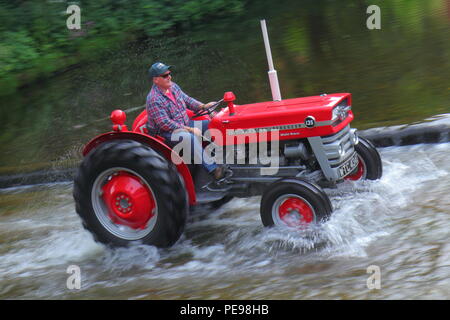 Eine rote Massey Ferguson Traktoren den Fluss Skell Ford Kreuzung in Ripon, North Yorkshire Stockfoto