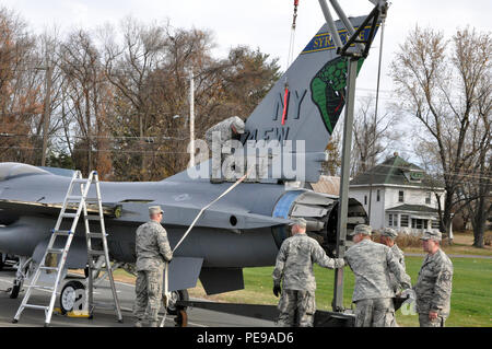 New York Air National Guard Flieger aus dem 174 Angriff Flügel, Syrakus, liefern und eine F-16 Kampfjets, außerhalb der NYS Abteilung von Militär und Marine Angelegenheiten zusammenbauen und Sitz der New York Army und Air National Guard für die ständige Anzeige in Latham, New York, 7. Das Flugzeug war seit mehr als 20 Jahren als Teil des 174. Der New York Air National Guard Fighter Wing geflogen und war im Jahr 2010, wenn der Flügel neu geordnet zurückgezogen. (U.S. Army National Guard Foto von Sgt. Große Corine Lombardo/freigegeben) Stockfoto