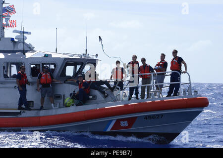 Am 10. November 2015 absolvieren Mitglieder der Coast Guard Station Honolulu-Crew an Bord eines 45-Fuß-Response Boat-Medium vor der Küste Oahu, Hawaii. Das Personal übt das Werfen von Greifhaken mit angebrachten Trackern auf Trümmerverschränkungen, um reale Rettungsszenarien zu simulieren. Die Übung wird jährlich mit Unterstützung der NOAA durchgeführt, um eine effektive Reaktion, Teamarbeit und Sicherheitsvorkehrungen für die Unterstützung von Walen zu gewährleisten, die sich in der Nähe von Oahu verfangen. Die Schulung verbessert den Schutz von Meerestieren und verbessert die Einsatzbereitschaft. Stockfoto