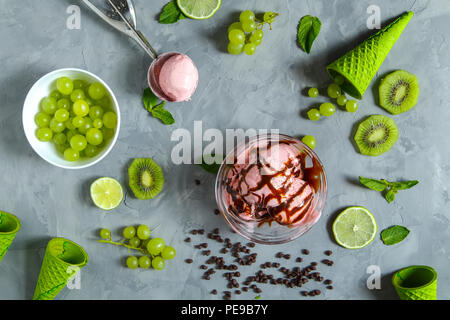 Erdbeereis mit verschiedenen Beeren und Minze auf grauem Hintergrund. Stockfoto