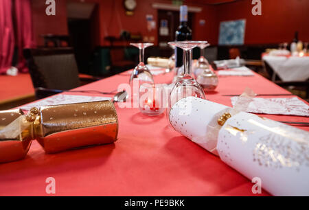 Partytisch mit Crackern, Gläsern und Rotwein auf die Gäste, Stockfoto