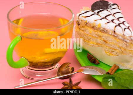 Tasse entspannenden würzige Zitrone Tee mit Layer Cake gekrönt mit dekorativen cremige Sahnehäubchen auf eine bunte rosa Hintergrund Stockfoto