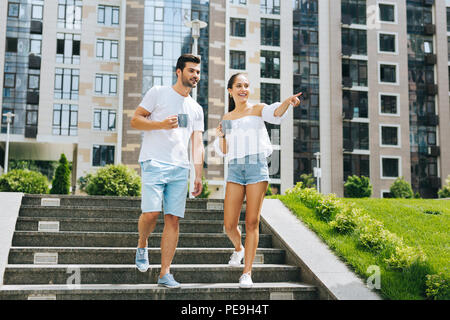 Positive freudige Frau zeigt mit dem Finger Stockfoto