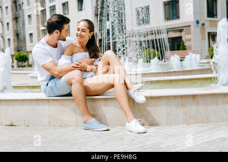 Angenehmer netter Mann seine Freundin umarmen Stockfoto