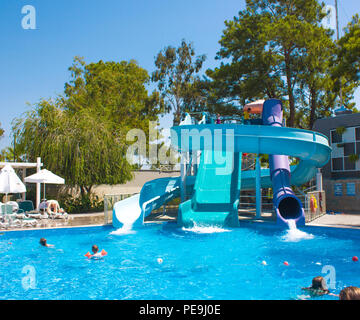 KEMER, Antalya, Türkei - 19 Juli, 2018: großer Pool mit Wasserrutschen im Barut Hotel mit einem Menschen unter blauem Himmel Stockfoto