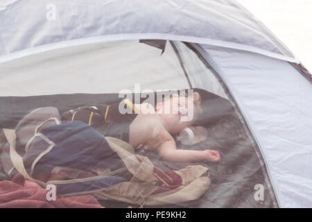 Zwei Jahre alten Jungen schlafen in eine Strandmuschel, Devon, England, Vereinigtes Königreich. Stockfoto