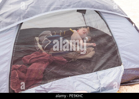 Zwei Jahre alten Jungen schlafen in eine Strandmuschel, Devon, England, Vereinigtes Königreich. Stockfoto