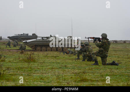 Bulgarische Soldaten von 1/61 St mechanisierten Bataillons auf Linie entlang der Seite des Boyevaya Mashina Pekhoty 1 (BMP-1) den Feind während der Übung Frieden Sentinel bei Novo Selo Training Center, Bulgarien, Nov. 24, 2015 zu unterdrücken. (U.S. Armee Foto: Staff Sgt. Steven M. Colvin/Freigegeben) Stockfoto