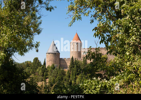 Blick auf die beiden Türme von Carcassonne Zitadelle von Bäumen an einem sonnigen Tag umrahmt. Stockfoto