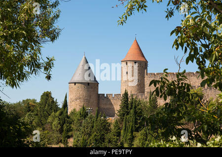 Blick auf die beiden Türme von Carcassonne Zitadelle von Bäumen an einem sonnigen Tag umrahmt. Stockfoto