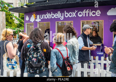 Besucher in Edinburgh Festival Fringe Queuing für Tickets an der Underbelly Box Office in Bristo Square im Zentrum der Stadt. Stockfoto