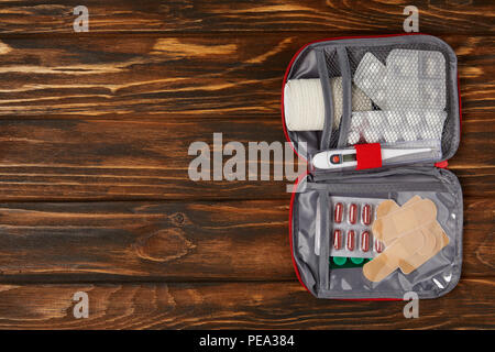Ansicht von oben eröffnet Erste Hilfe Kit Tasche auf hölzernen Tischplatte Stockfoto