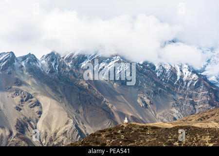 Weißer Stein buddhistische Stupa auf dem Hintergrund der Berge, Nepal. Die schneebedeckten Berge in den Wolken. Stockfoto