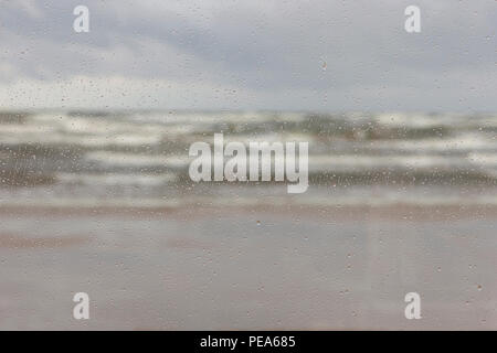 Der Sturm mit Wellen und Horizont in der Ostsee durch die Regentropfen auf dem Glas Stockfoto