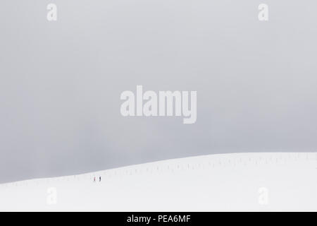 Ein sehr minimalistisches Blick auf zwei weit entfernte Menschen über einen Berg von Schnee bedeckt Stockfoto