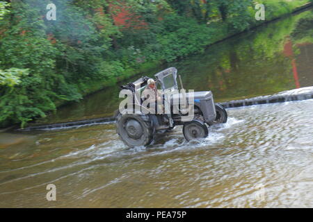 Lassen Sie den Traktor laufen sieht, Traktoren und andere Fahrzeuge im Konvoi den Fluss überqueren, als Sie in Ripon Stadtzentrum entfernt von Newby Hall North Yorks Kopf. Stockfoto