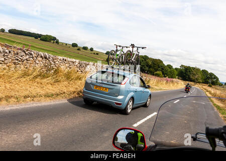 Fahrräder werden auf einem Auto wie von einem Motorrad gesehen. Peak District, Derbyshire. Stockfoto