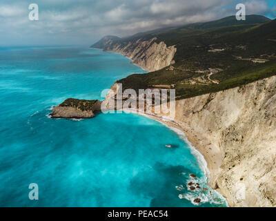 Ausblick auf das türkisfarbene Meer Wasser mit wilden Meer und Wellen erreichen Sandstrand und steile Felsen an einem sonnigen Tag. Blick auf den Porto Katsiki Stockfoto