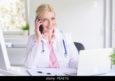 Schuß von lächelnden Frau am Telefon sprechen und Beratung mit ihren Patienten. Stockfoto