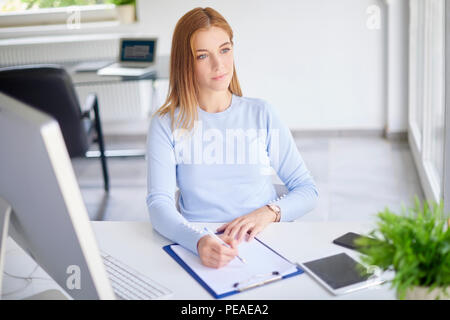 High Angle Shot der jungen Geschäftsfrau, Sitzen im Büro und dabei einige Schreibarbeit. Stockfoto