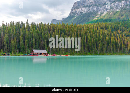 Banff, Kanada - August 03, 2018. Touristen nehmen Kanus auf das Türkis Wasser des Lake Louise, Banff, Kanada mit den Rocky Mountains im drohenden Stockfoto