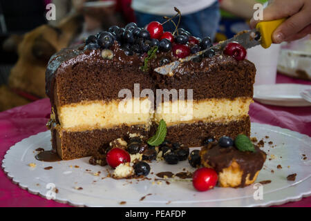 Schneiden Sie ein Stück von geschichteten Kuchen Stockfoto