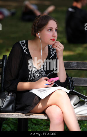 NEW YORK, NY - 05. SEPTEMBER: junge weiße Frau Studium ein Buch, während sitzen auf einer Bank in Washington Square Park, Manhattan am 5. September 2016 in N Stockfoto