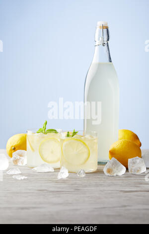 Flasche und Gläser der traditionellen italienischen Limoncello auf hölzernen Tischplatte Stockfoto