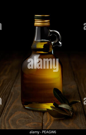 Flasche aromatischen Olivenöl mit Verzweigung auf Holz- Oberfläche Stockfoto