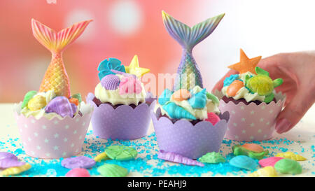 Mermaid Thema Cupcakes mit bunten glitter Schwänze, Muscheln und Meerestiere toppers für Kinder, jugendlich, Neuheit Geburtstag und Party feiern. Stockfoto