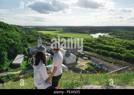 Junges Paar reist auf einem Hügel und genießen Sie den herrlichen Blick auf das Tal, den Fluss und das Kloster Stockfoto