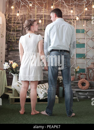 Ansicht der Rückseite. glückliches Paar stehend auf dem Teppich im stilvollen Wohnzimmer. Stockfoto