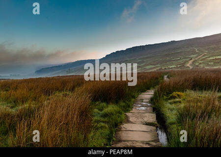 Landschaft Bild aus dem Peak District, ein Weg, der bis zu den Hathersage Kante. An einem kühlen nebligen Morgen wandern auf dem Weg durch die Gräser. Stockfoto