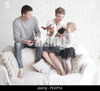 Portrait von glücklichen Eltern mit ihrer Tochter und geliebten Haustieres mit einem Wohnzimmer Stockfoto