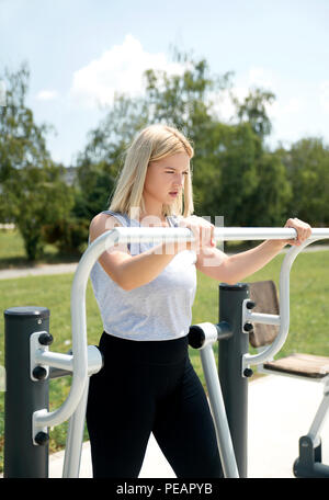 Junge Frau Training im Freien mit Fitnessgeräten. Stockfoto