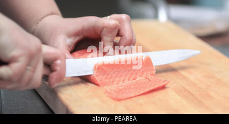 Bis zu schließen. Küchenchef schneiden Fisch für Sushi Stockfoto